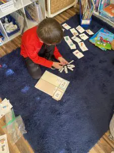 A boy is playing with cards on the floor