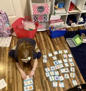 A girl is playing with cards on the floor