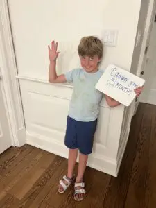 A young boy holding up a sign that says 'thank you'.