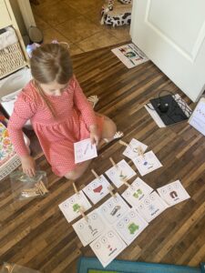 A little girl sitting on the floor with a set of cards.