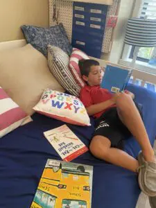 A boy laying on a bed reading a book.