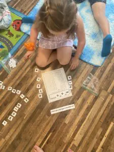 A little girl is playing with letters on the floor.