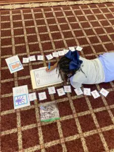 A girl is laying on the floor with a piece of paper.