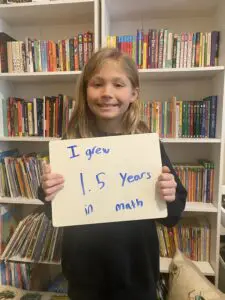 A girl holding up a sign that says 15 years in math.