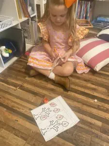 A little girl sitting on the floor with a piece of paper.
